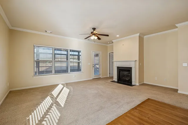 a view of an empty room with a fireplace and a window