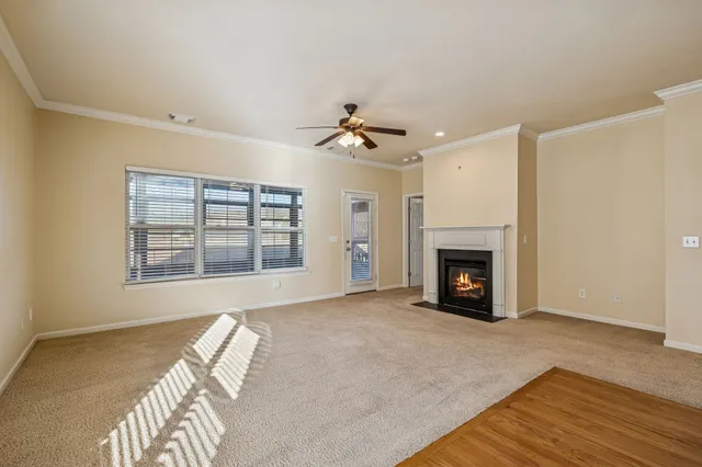 a view of an empty room with a fireplace and a window