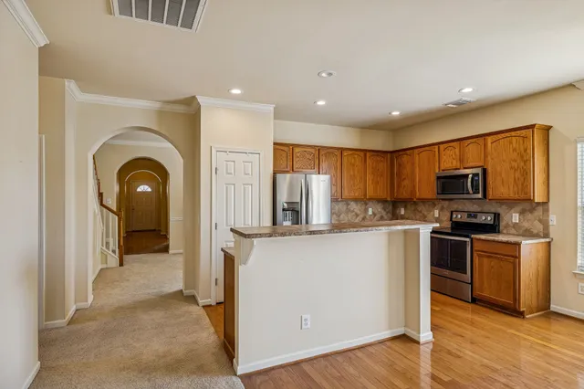 a view of a kitchen with stainless steel appliances granite countertop a stove top oven