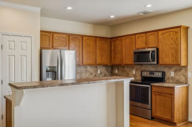 a kitchen with stainless steel appliances granite countertop a refrigerator stove microwave and sink