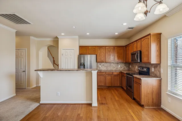 a kitchen with stainless steel appliances granite countertop a sink stove and refrigerator