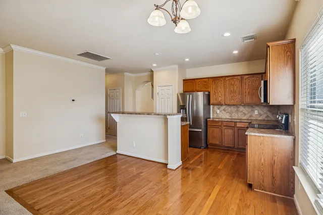 a kitchen with stainless steel appliances granite countertop a refrigerator a sink dishwasher a stove and a microwave oven on granite countertops