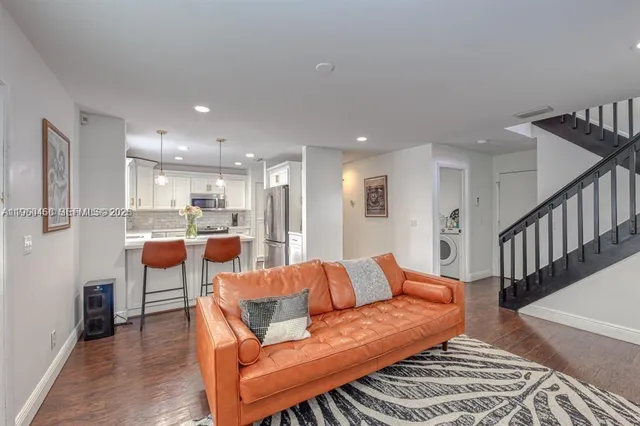 a living room with furniture and a dining table with wooden floor