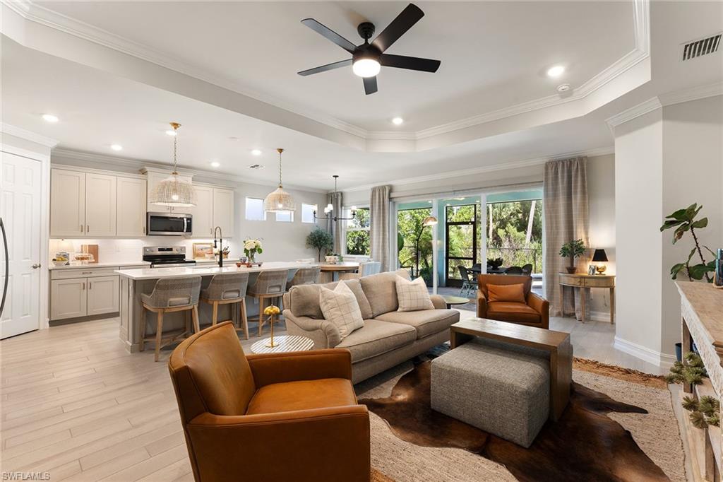 394 Deauville Loop Naples, FL 34114 - Photo 12 of 50 a living room with furniture kitchen area and a wooden floor