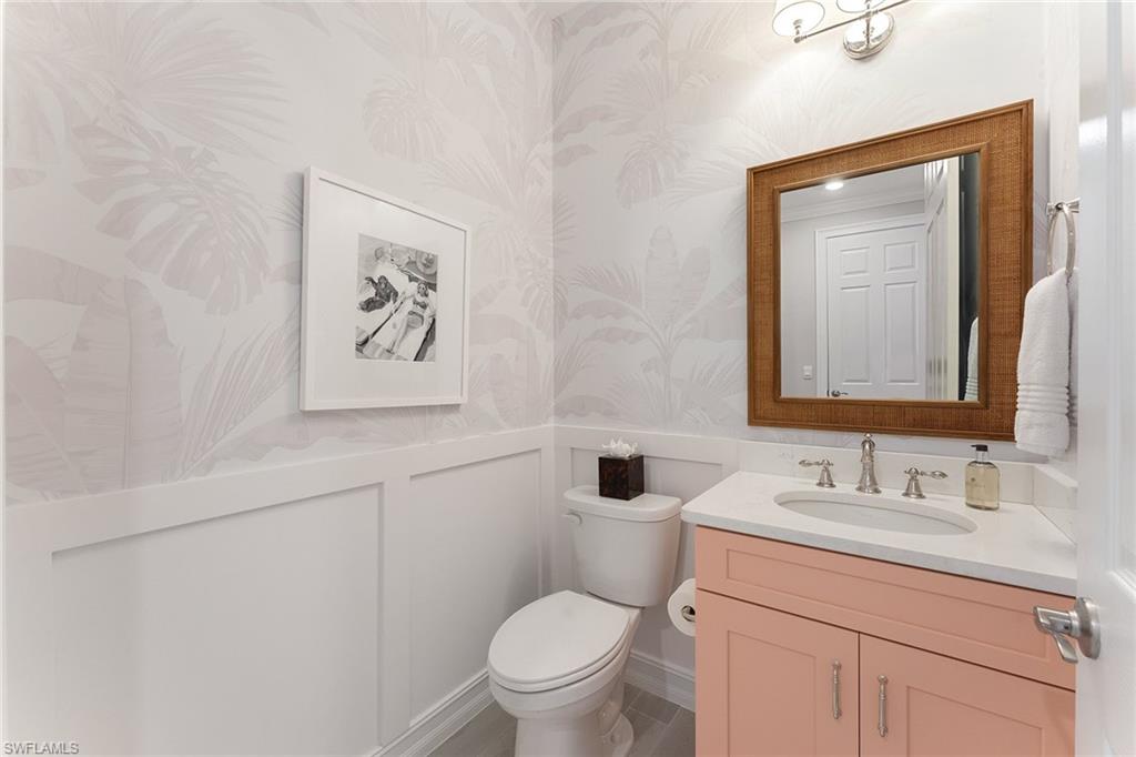 394 Deauville Loop Naples, FL 34114 - Photo 28 of 50 a bathroom with a toilet a sink and mirror