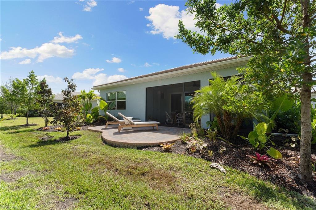 394 Deauville Loop Naples, FL 34114 - Photo 47 of 50 a table and chairs in front of a house