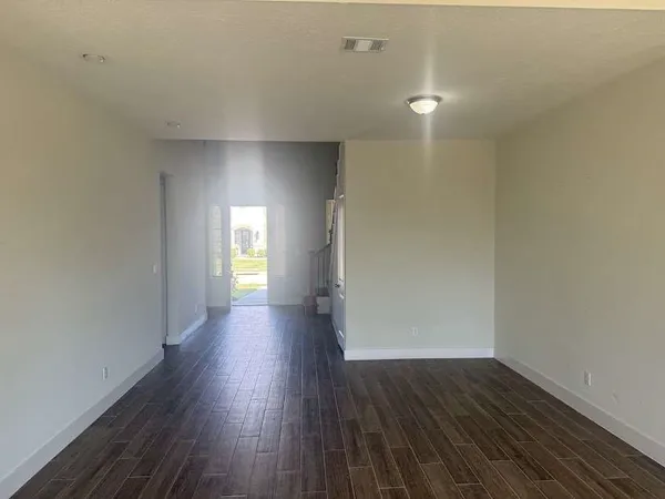 a view of empty room with wooden floor