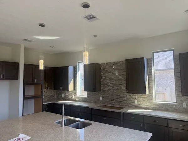 a kitchen with stainless steel appliances granite countertop a sink and a refrigerator