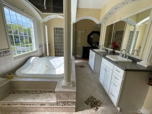 a bathroom with a tub sink and mirror