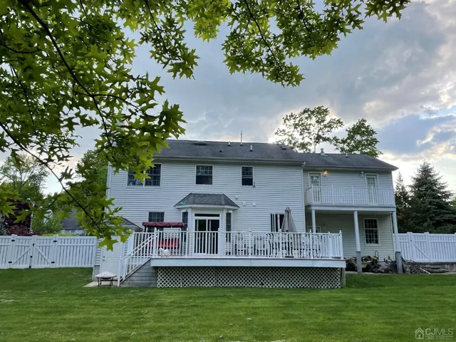 a front view of a house with a garden and lake view