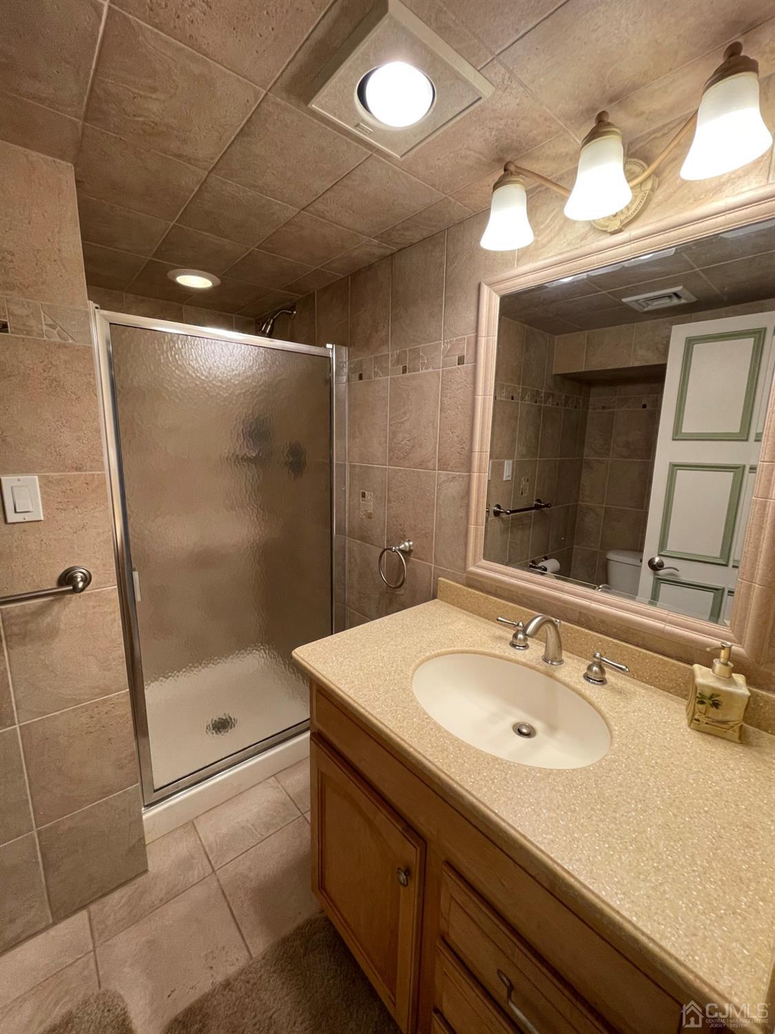 12 Ramsey Road Edison, NJ 08820 - Photo 29 of 30 a bathroom with a sink shower and mirror