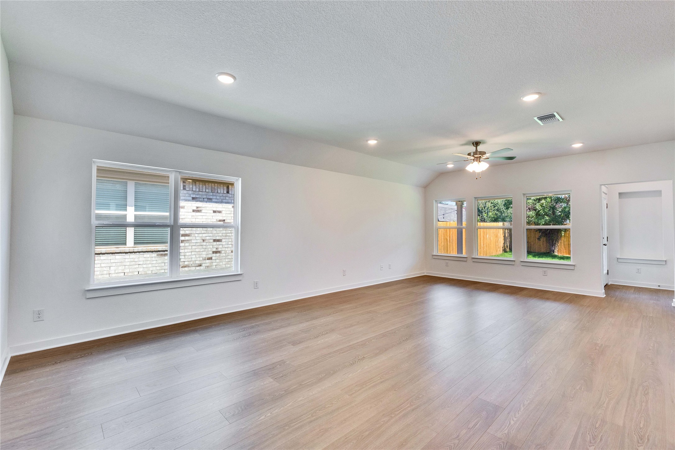 13509 Barn Chime Street Elgin, TX 78621 - Photo 36 of 40 Open-concept living space with wood-finish flooring, vaulted ceiling, recessed lighting, and a ceiling fan
