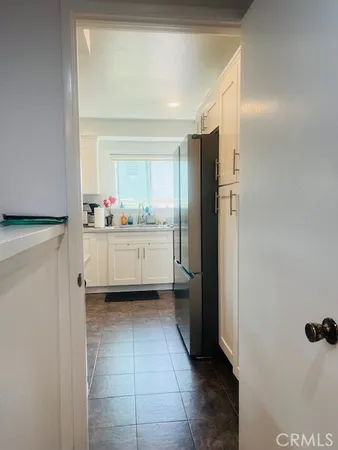 a kitchen with a sink a refrigerator and cabinets