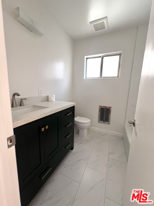 6610 Whitsett Avenue, Unit 1 North Hollywood, CA 91606 - Photo 7 of 11 a spacious bathroom with a toilet sink and mirror