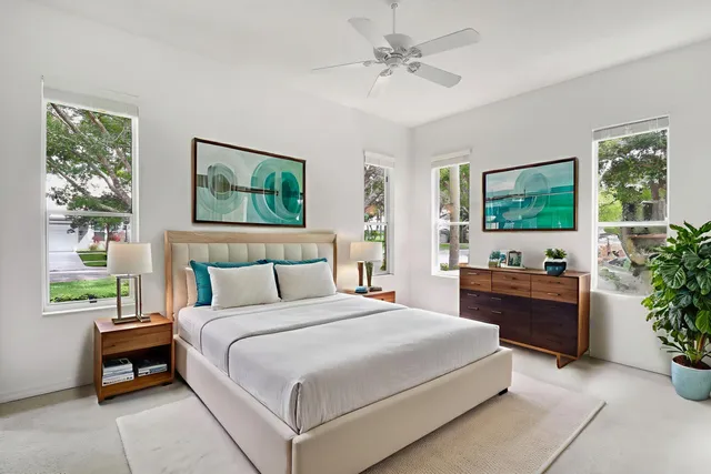 a bedroom with a large bed and a potted plant