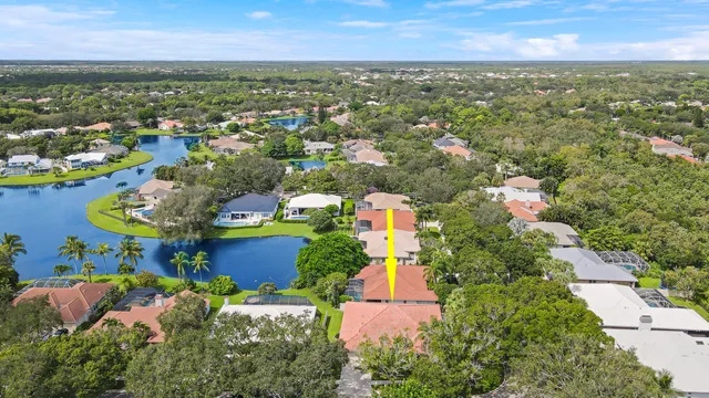 an aerial view of residential houses with outdoor space and trees all around
