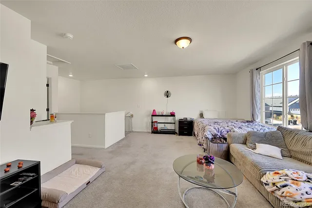 a kitchen with stainless steel appliances granite countertop a refrigerator oven stove a sink a dining table and chairs with wooden floor