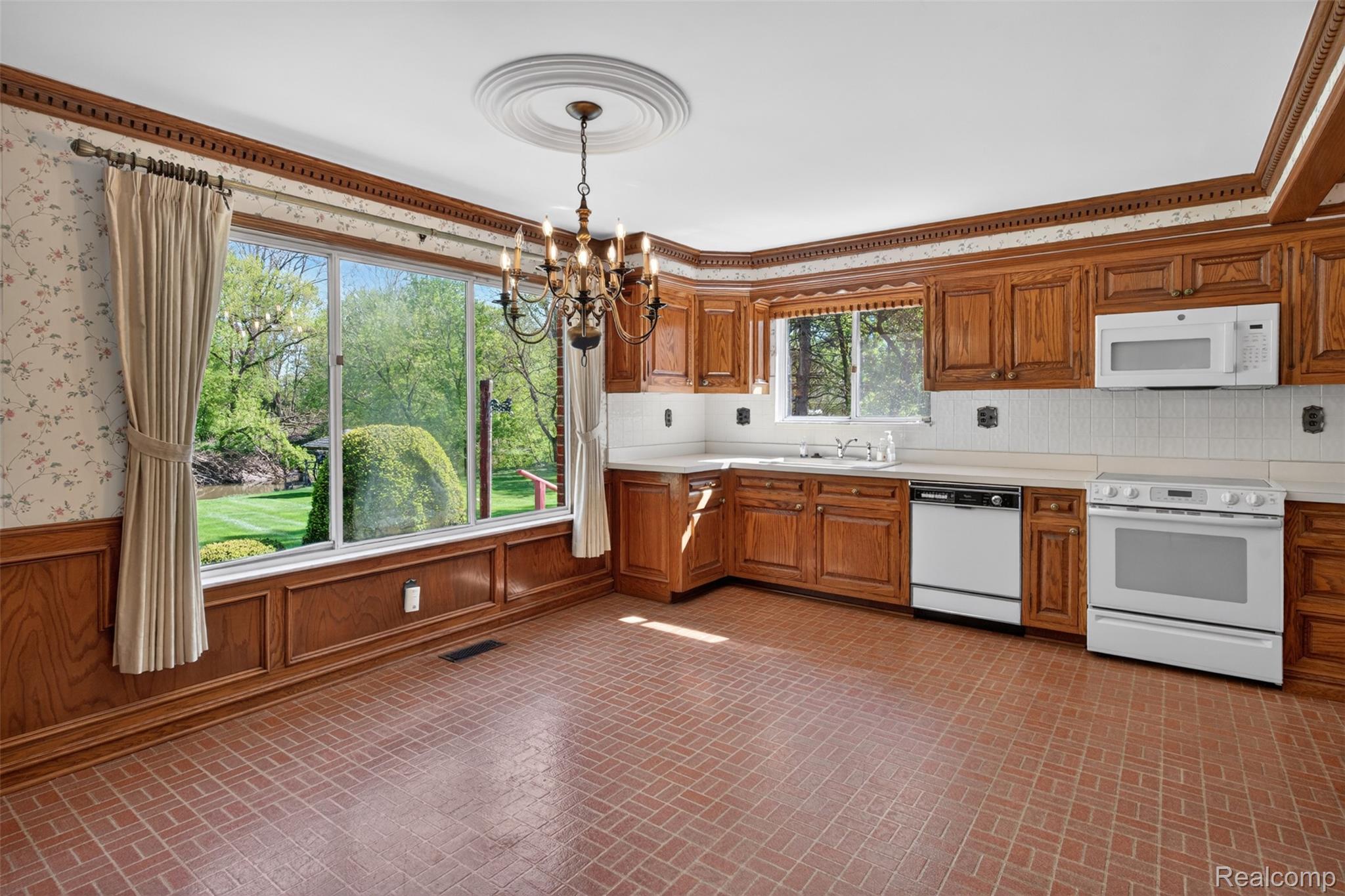 15623 Millar Road Clinton Township, MI 48036 - Photo 41 of 56 Kitchen featuring brick patterned floors, white appliances, hanging lights, light countertops, and wood finish cabinetry