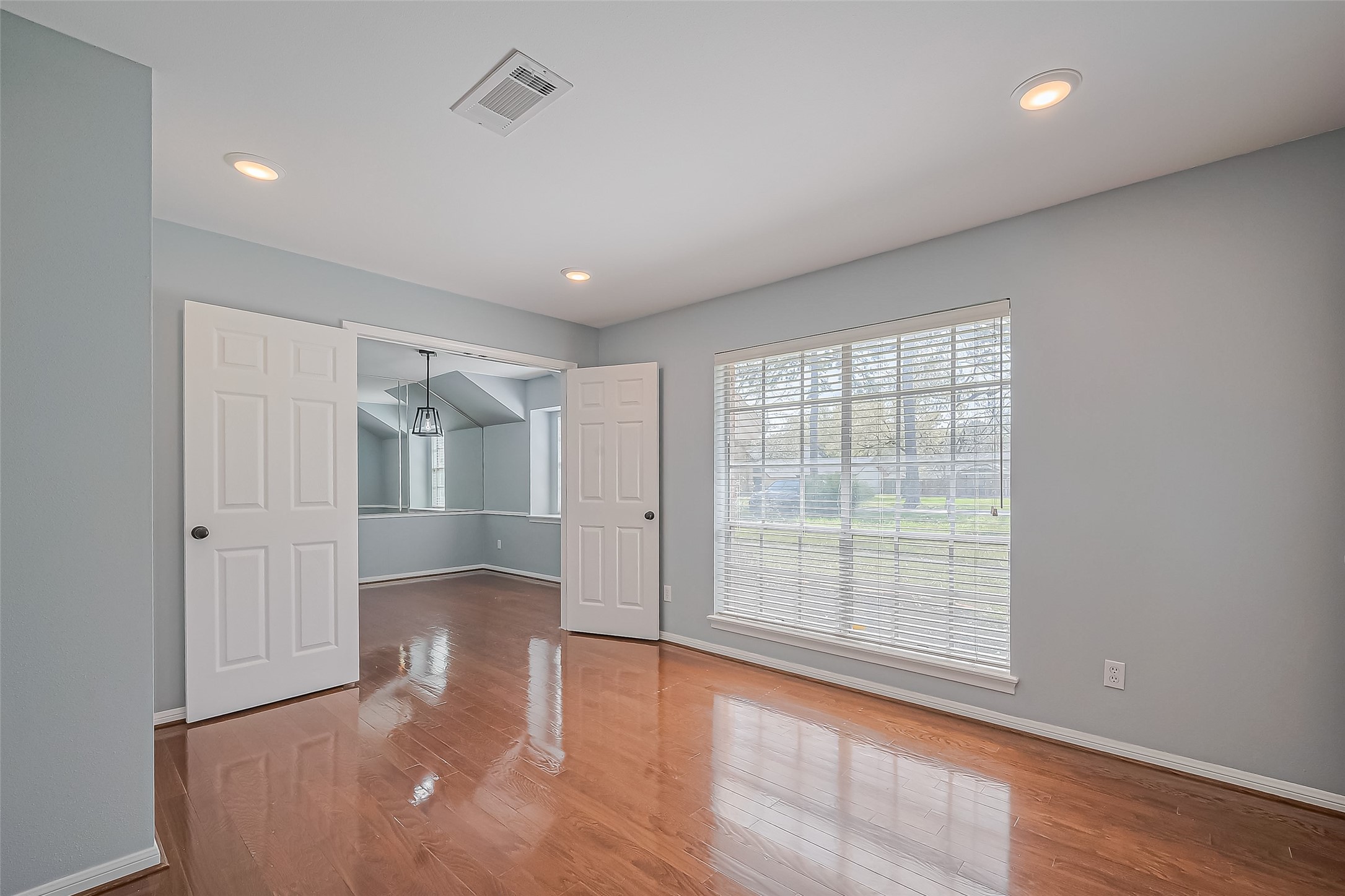 16506 Amcreek Road Houston, TX 77068 - Photo 16 of 50 an empty room with wooden floor and windows