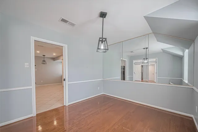 a view of empty room with wooden floor