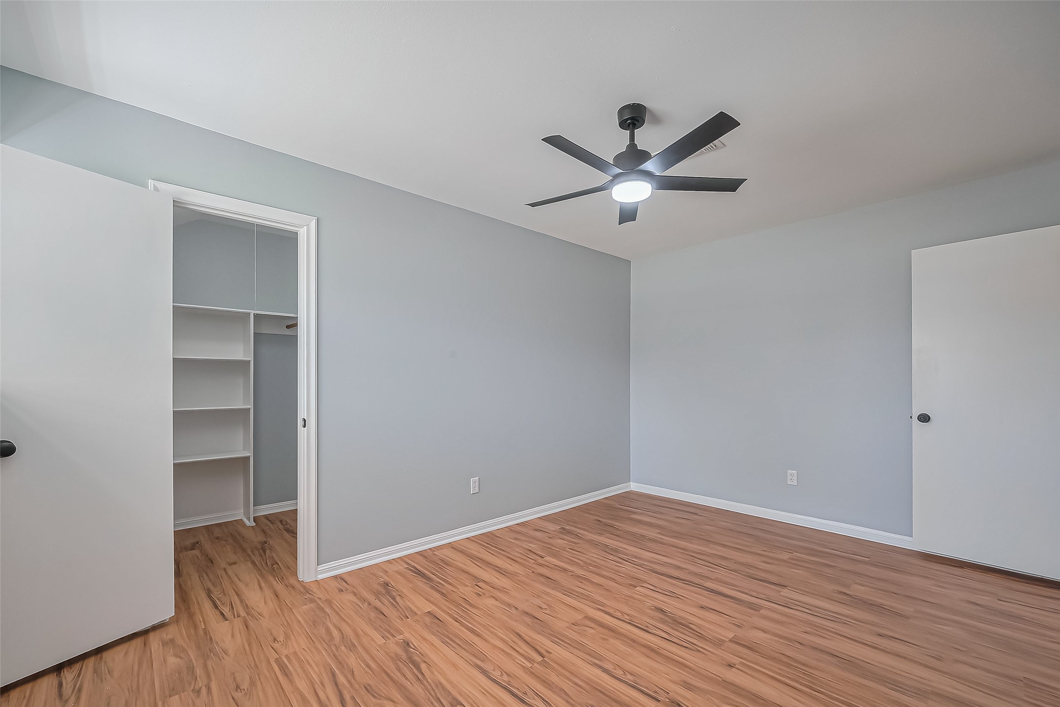 16506 Amcreek Road Houston, TX 77068 - Photo 30 of 50 a view of a room with wooden floor and a ceiling fan