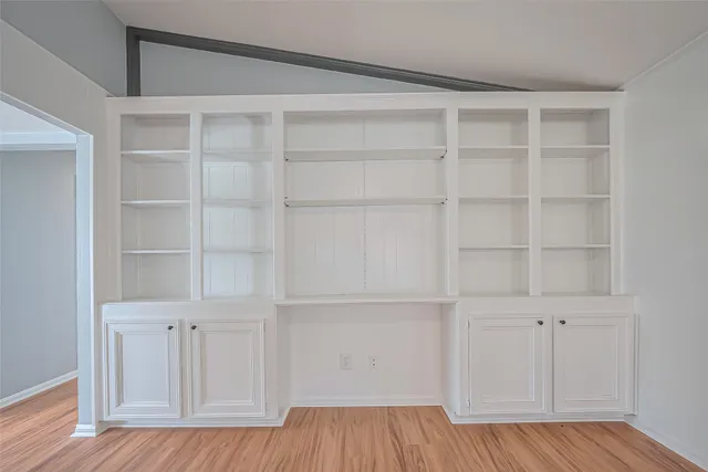a view of a room with wooden floor and cabinet