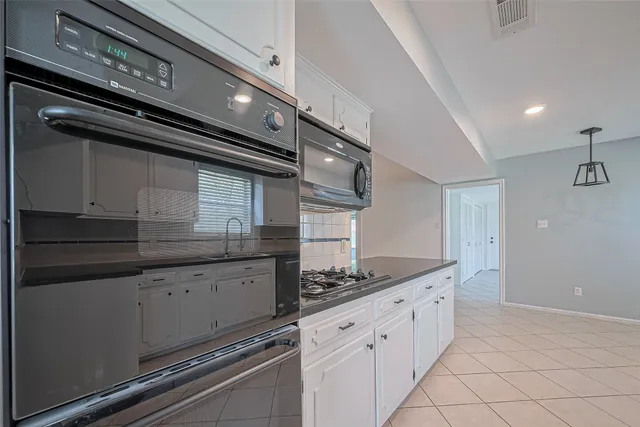 a kitchen with granite countertop a sink and a refrigerator