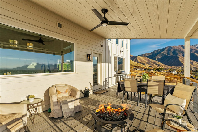 1800 Spring Oaks Drive Springville, UT 84663 - Photo 27 of 68 Deck with a mountain view, outdoor dining area, a ceiling fan, and a fire pit