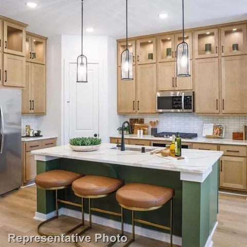 a kitchen with stainless steel appliances granite countertop a sink a stove and a refrigerator