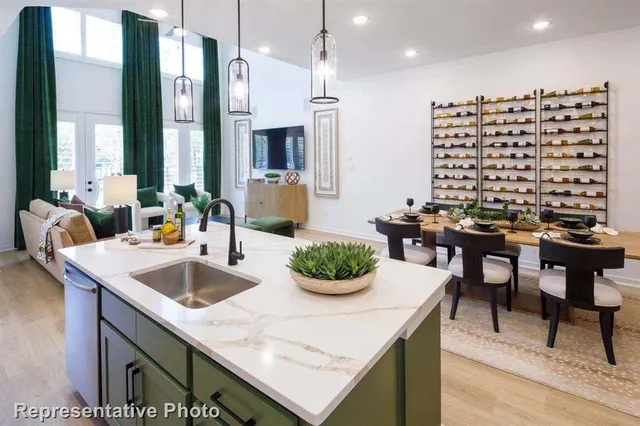 a kitchen with kitchen island granite countertop a sink and white cabinets