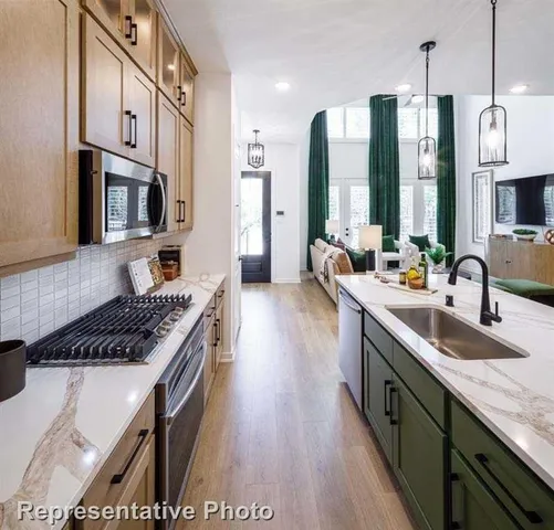 a kitchen with stainless steel appliances granite countertop a stove a sink and a refrigerator