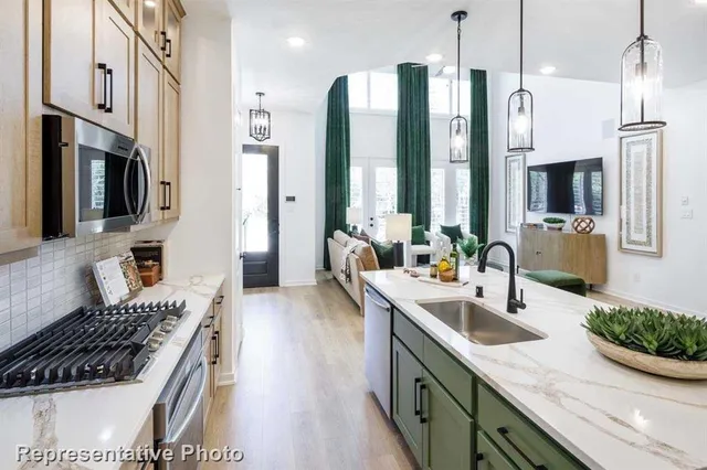 a kitchen with stainless steel appliances a sink stove and refrigerator