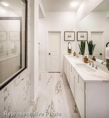 a spacious bathroom with a double vanity sink and mirror