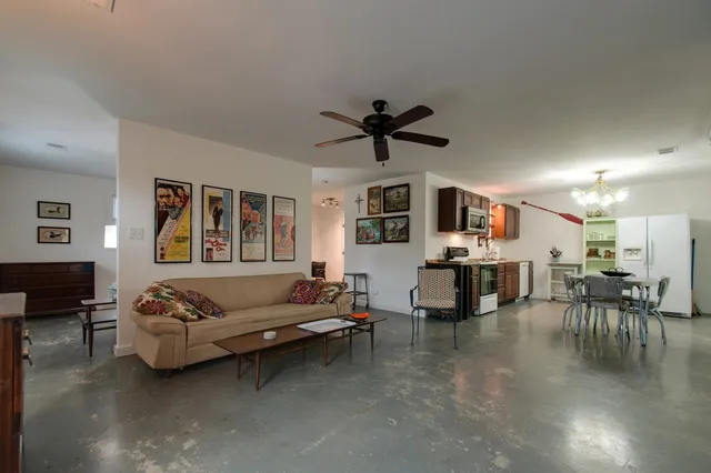 a living room with furniture kitchen view and a flat screen tv
