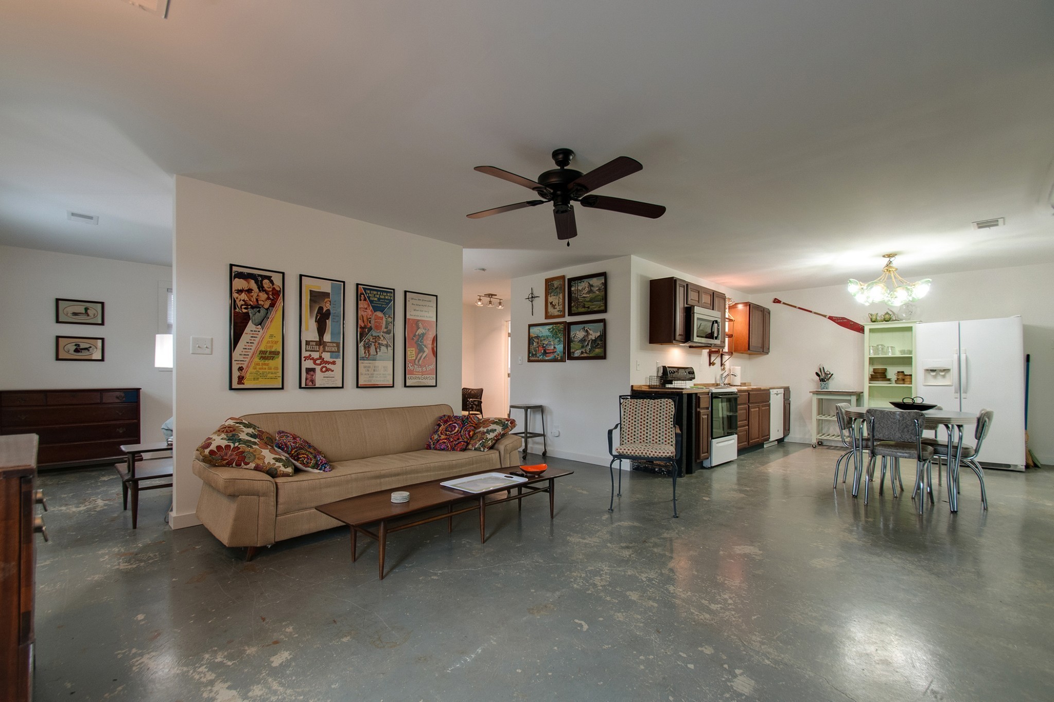 a living room with furniture kitchen view and a flat screen tv