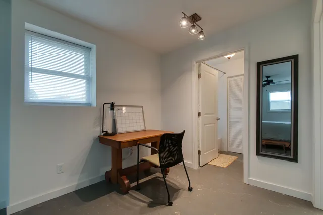 a view of a workspace with furniture and a window
