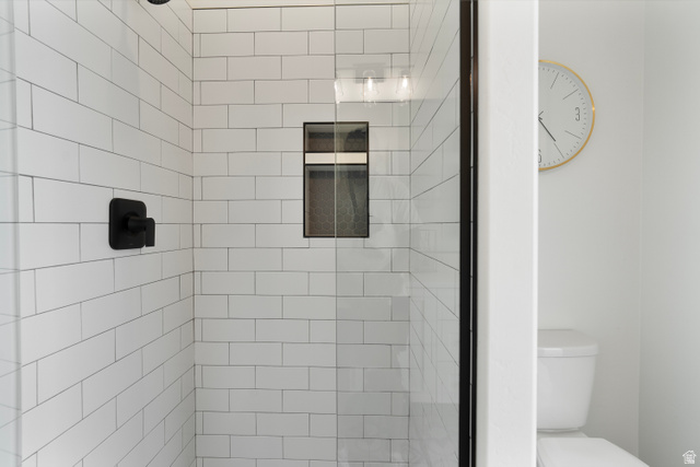 2278 Tawny Ridge Circle St. George, UT 84790 - Photo 35 of 61 Shower enclosure featuring subway tile walls, a built-in shower niche, and a matte black shower fixture.