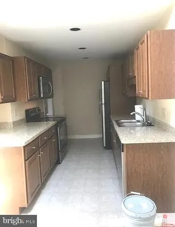 a kitchen with a sink cabinets and toilet