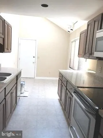 a kitchen with stainless steel appliances granite countertop a sink stove and cabinets