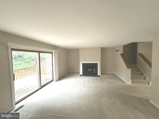 a view of an empty room with a fireplace and a window