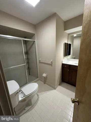 a bathroom with a toilet a sink and glass door