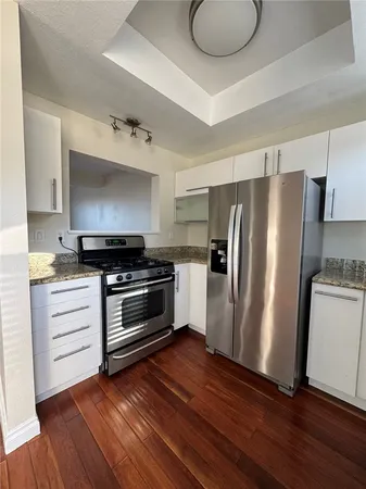 a kitchen with wooden floors and appliances