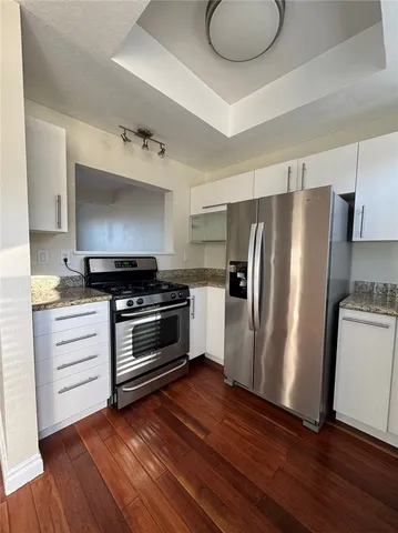 a kitchen with wooden floors and appliances