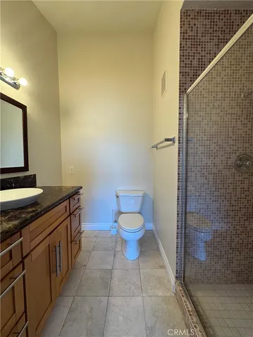 a bathroom with a granite countertop toilet and a sink