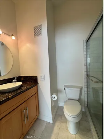 a bathroom with a granite countertop toilet and a sink