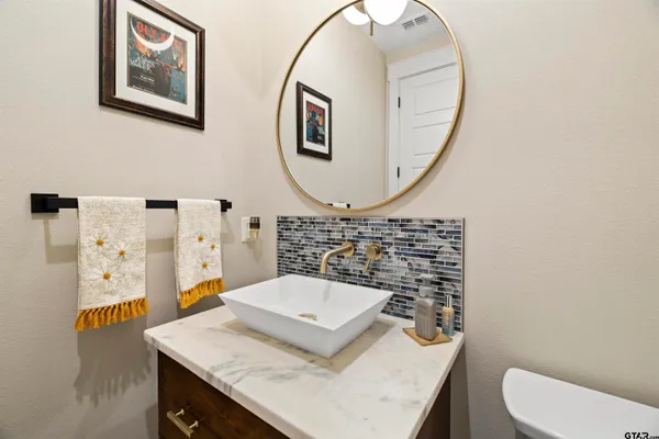 a bathroom with a sink a toilet and a mirror