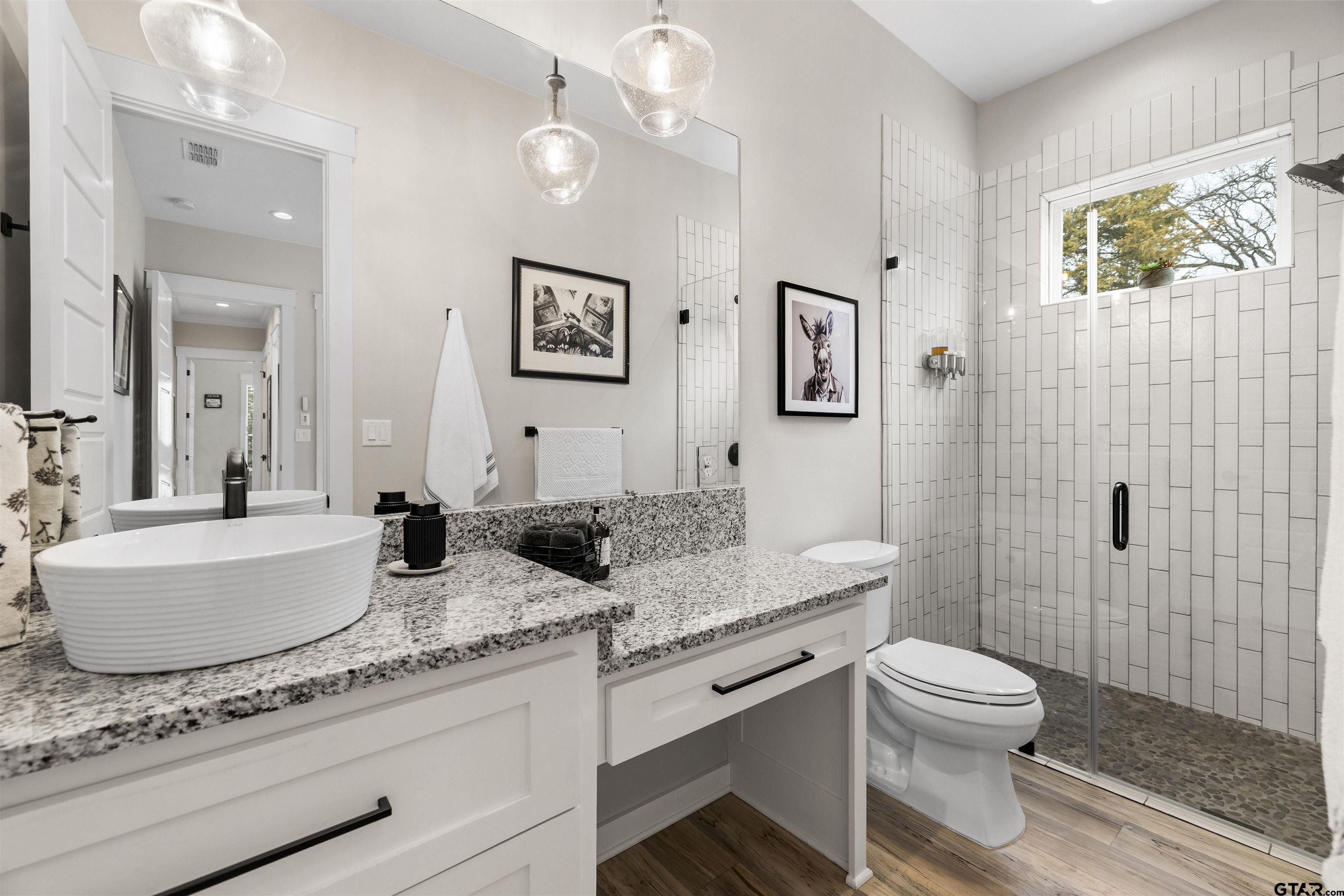 23316 Fm 1995 Lindale, TX 75771 - Photo 29 of 47 a bathroom with a granite countertop toilet a sink a mirror and a shower