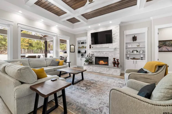 a living room with stainless steel appliances kitchen island granite countertop a sink a stove and a refrigerator