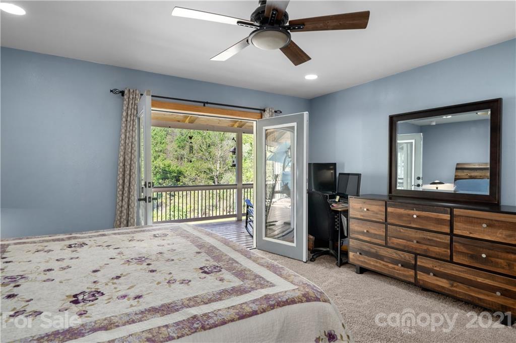301 Fowler Lane Clyde, NC 28721 - Photo 13 of 47 a bedroom with a bed and large mirror