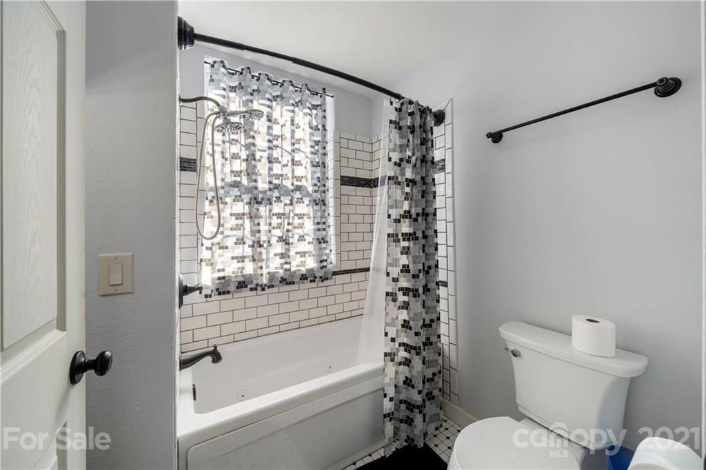301 Fowler Lane Clyde, NC 28721 - Photo 34 of 47 a bathroom with a toilet and a shower curtain